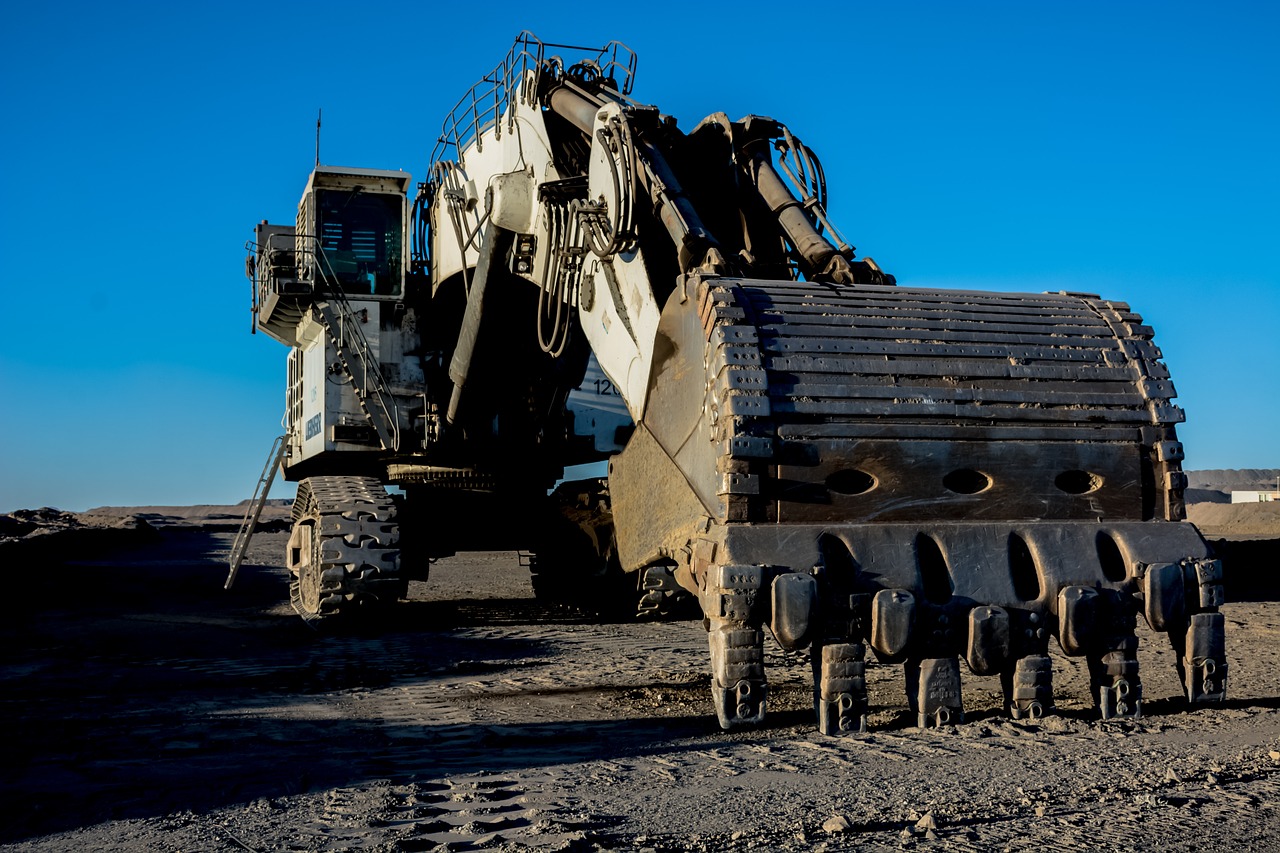 Close-up shot from the front of an excavator digging into the earth on a mining site