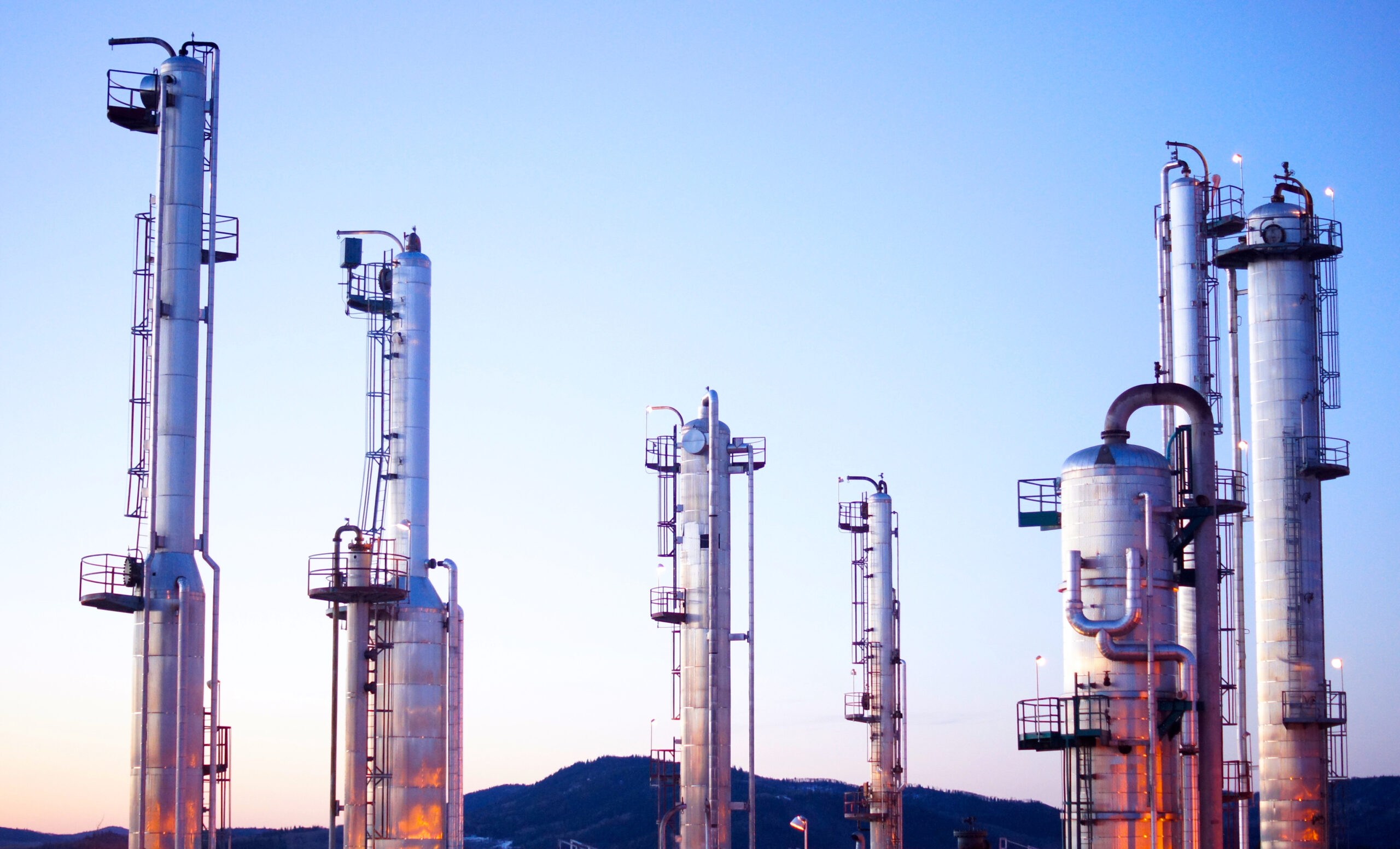 Distant exterior shot of oil and gas facility at dawn